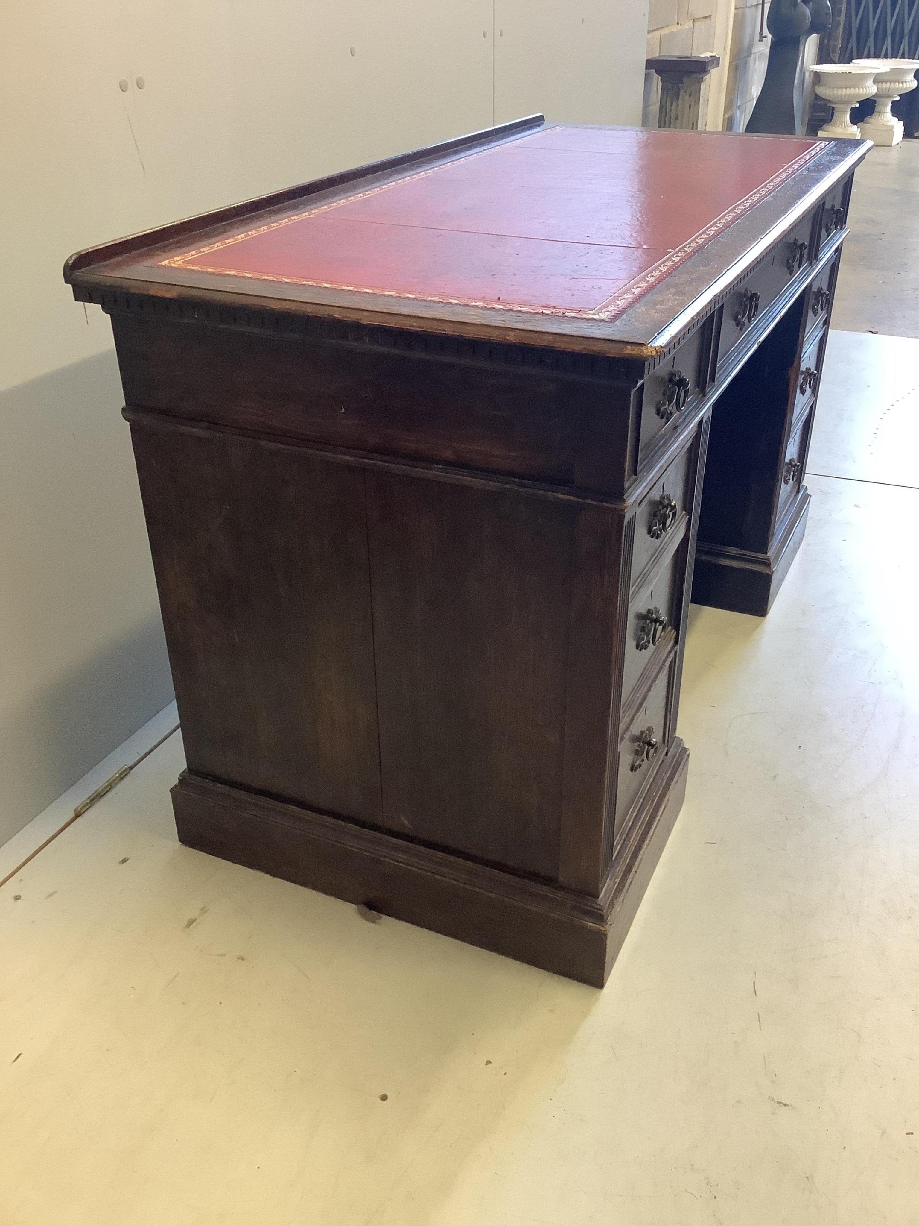 A late Victorian oak pedestal desk, width 128cm, depth 61cm, height 77cm. Condition - fair